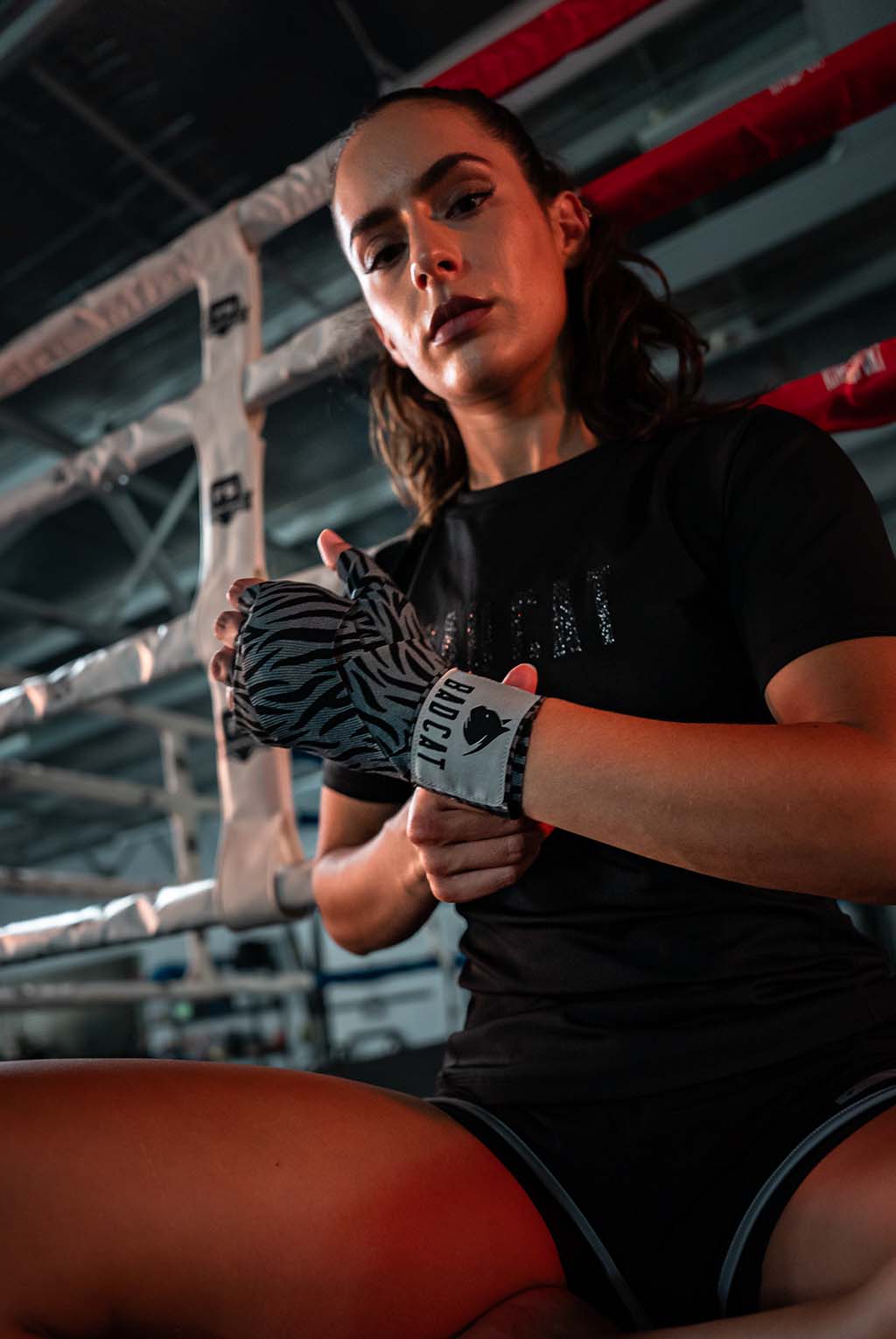 Person preparing for a boxing match with wrapped hands in a boxing ring.