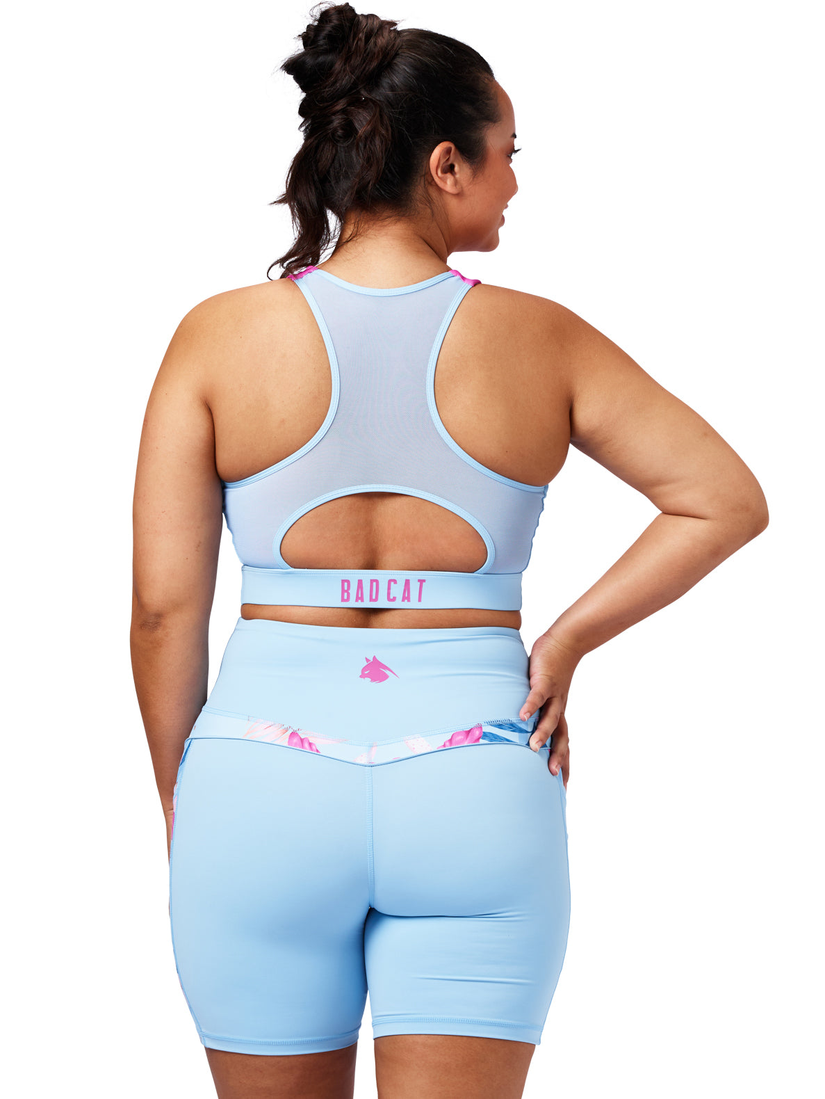 Woman wearing a light blue sports bra and shorts set with 'Babycat' branding on a white background