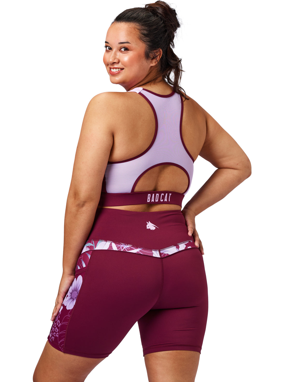 Woman wearing a sports bra and shorts with 'Bad Cat' branding on a white background