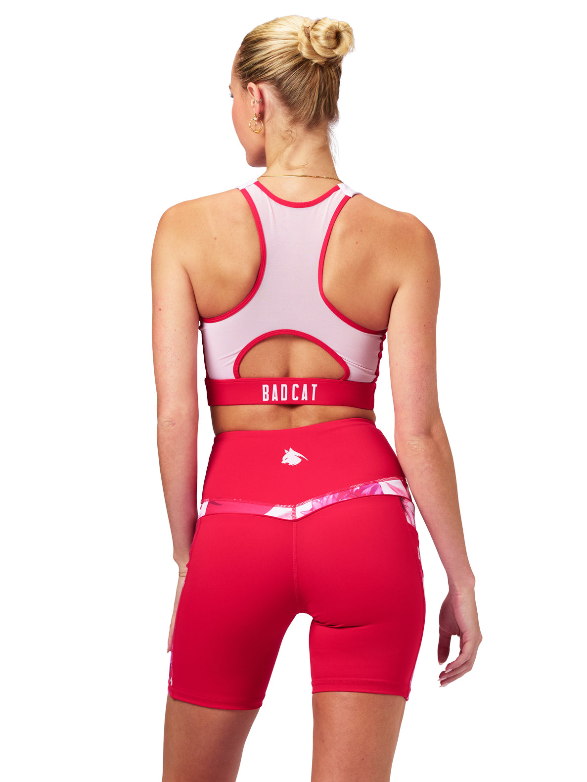 Woman wearing a red and white sports outfit with 'BAD CAT' branding on a white background